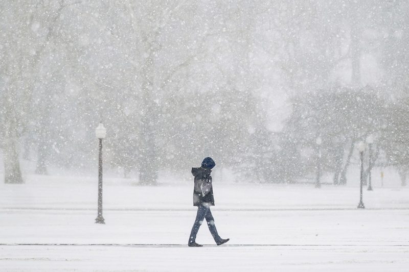 A student braves the Drillfield during a snowfall on January 16, 2022