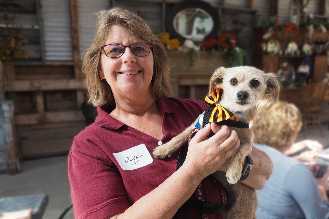 Debbie holds a Terrier wearing a bow-tie