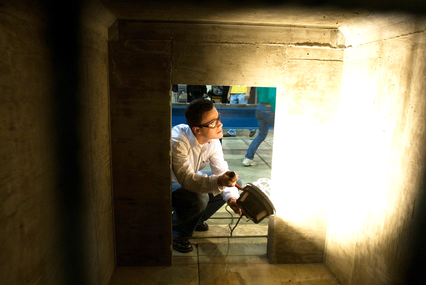 Person using a light to inspect the inside of an old structure