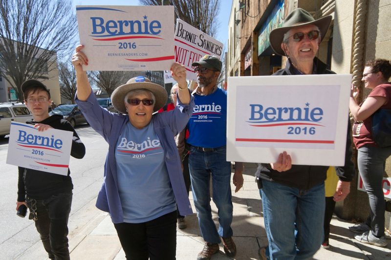 Supporters of Bernie Sanders’ 2016 presidential campaign march through the streets of downtown Asheville, North Carolina, carrying signs. 