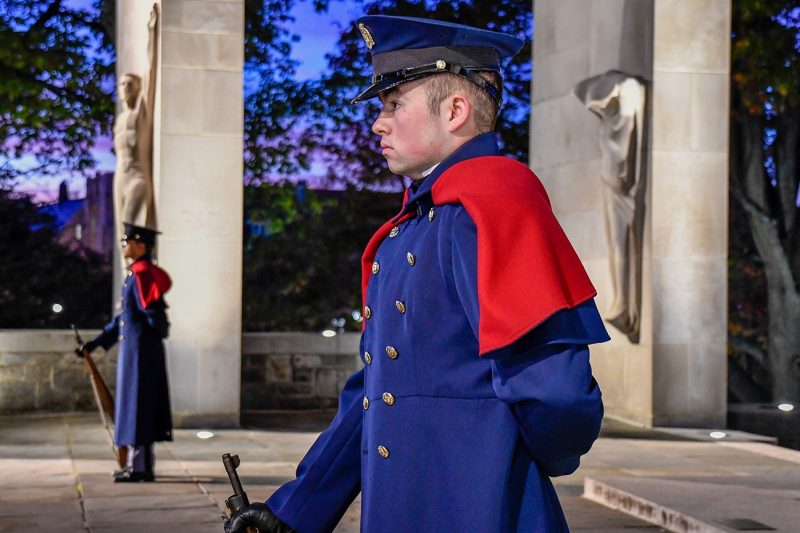 Two cadets in blue dress uniforms and capes stand guard at the Pylons.