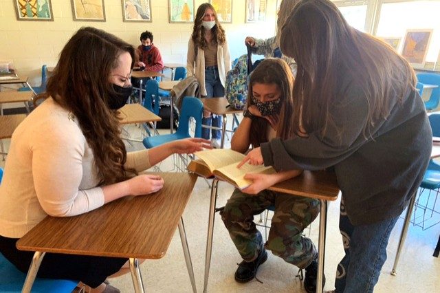 Heather Wright (left) works with high-school seniors in a classroom.