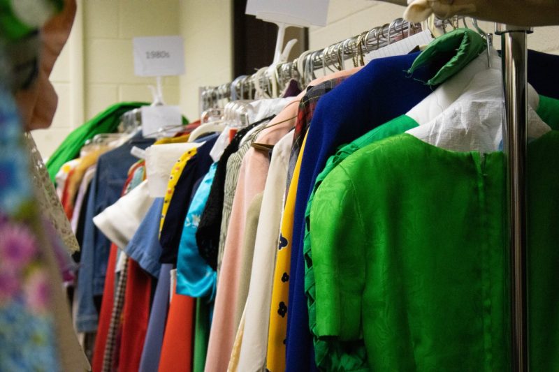 Colorful 20th-century dresses hang on a rack in the collection.