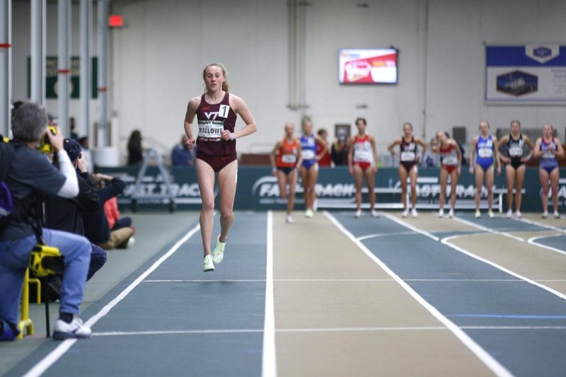 Hannah run toward the viewer on an indoor track, wearing her track and field uniform. 
