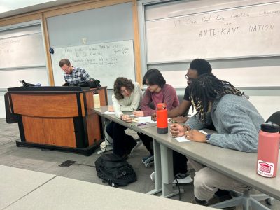 Members of Anti-Kant Nation huddle together to plan their response to a question. 