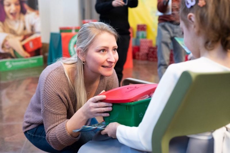 Elizabeth Groff hands an Operation Christmas Box to Natalya, an 8-year-old girl who was the recipient of the program's 200 millionth shoebox since the initiative's founding in 1993. 