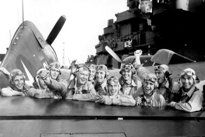 U.S. pilots, pleased over a victory in the Marshall Islands during World War II, grin across the tail of an F6F Hellcat on board the USS Lexington. Courtesy of the National Archives