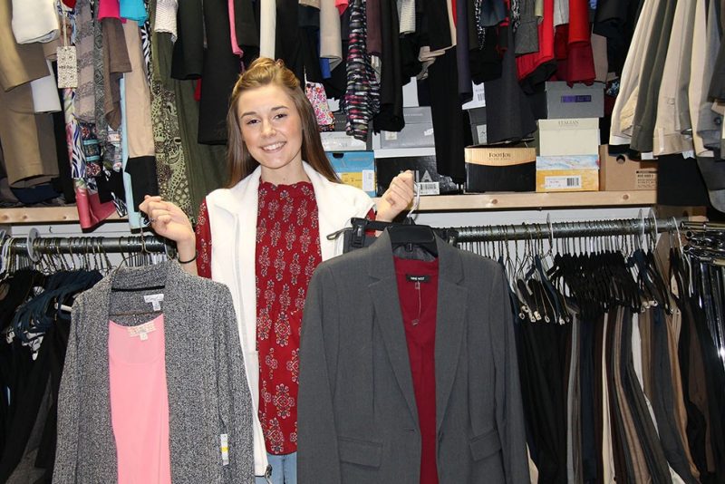 Blythe Boyd, a sophomore majoring in fashion merchandising and design, shows off some of the donations that will be available at the upcoming Career Outfitters event.