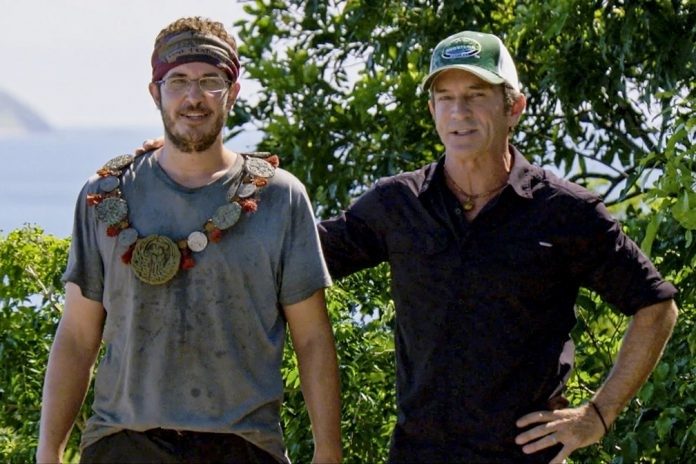 Show host Jeff Probst awards Rick Devens with the Immunity Necklace during the 10th episode of “Survivor: Edge of Extinction” on the CBS Television Network. Photo: Screen Grab/CBS Entertainment ©2019 CBS Broadcasting Inc. All Rights Reserved.