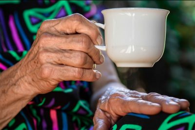 Hand of an elderly woman holding a coffee cup