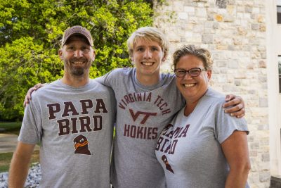 Family wearing matching Virginia Tech Papa Bird and Mama Bird shirts with their student.
