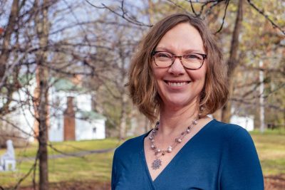 Female professor posing for photo outdoors.