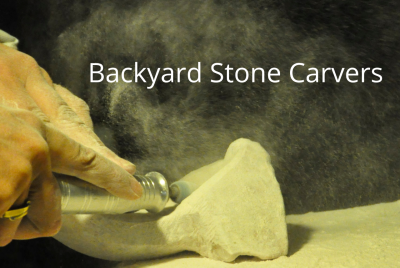 Two hands use a  tool to carve stone
