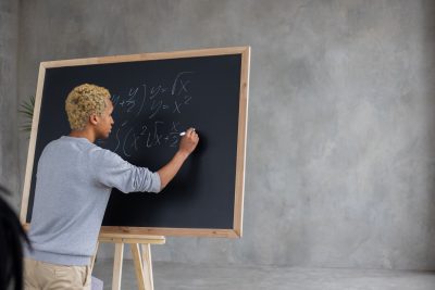 young man writing on a blackboard