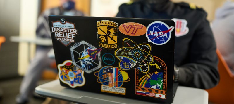 laptop covered in various stickers, including Virginia Tech VT logo and Nasa logo