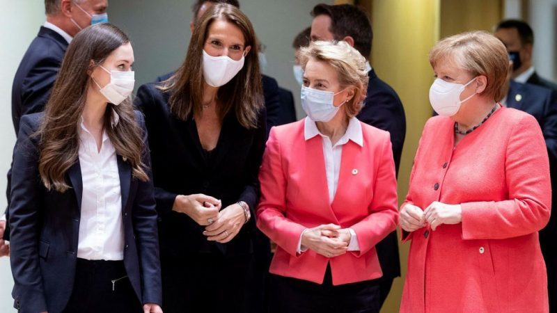 Women talk together while wearing masks