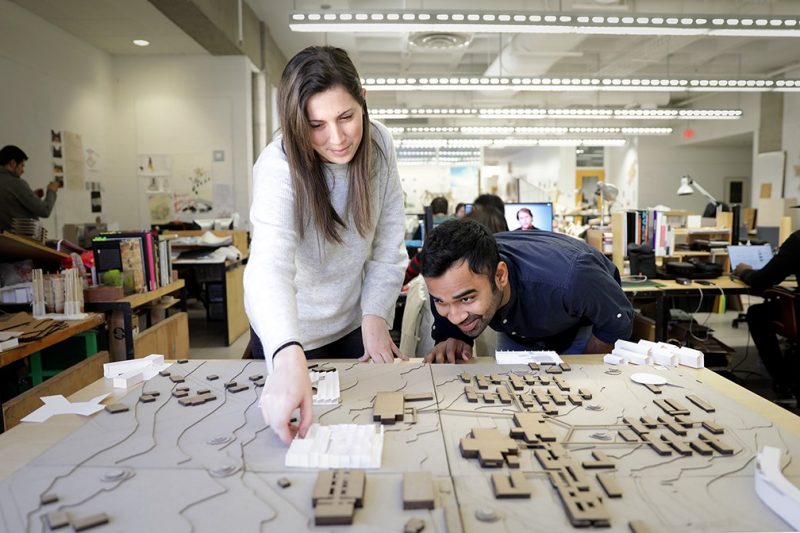 Virginia Tech architecture students Lindsey Blum (left) and Dhawal Jain work with a site model of Mzuzu University’s campus. They are members of a team designing a new library for the university in Malawi.