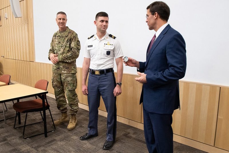 From left, Army ROTC Professor of Military Science Col. Paul Mele watches as Cadet Patrick Millikin receives a coin from Secretary of the U.S. Army Mark T. Esper. Mullikin, a senior majoring in political science and Russian, is ranked among the U.S. Army Cadet Command’s top 10 percent of all cadets nationwide commissioning an an officer this academic year. Photo courtesy of the Secretary of the U.S. Army’s Office.