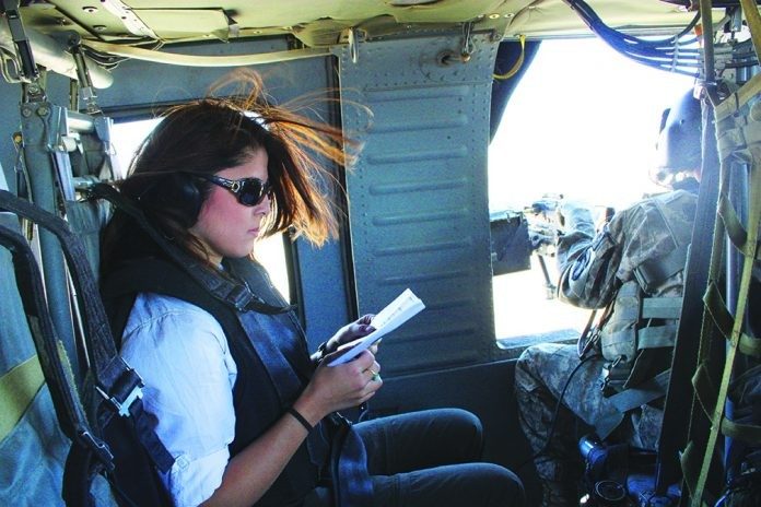 As a foreign correspondent for CNN, Atia Abawi often covered war zones. Here she reviews security briefing materials while traveling to Kunar Province in northeastern Afghanistan on a military helicopter. traveling to Kunar Province in northeastern Afghanistan on a military helicopter.