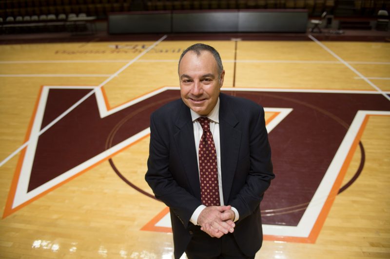 Professor of Practice Bill Roth stands on the basketball court of Cassell Coliseum.