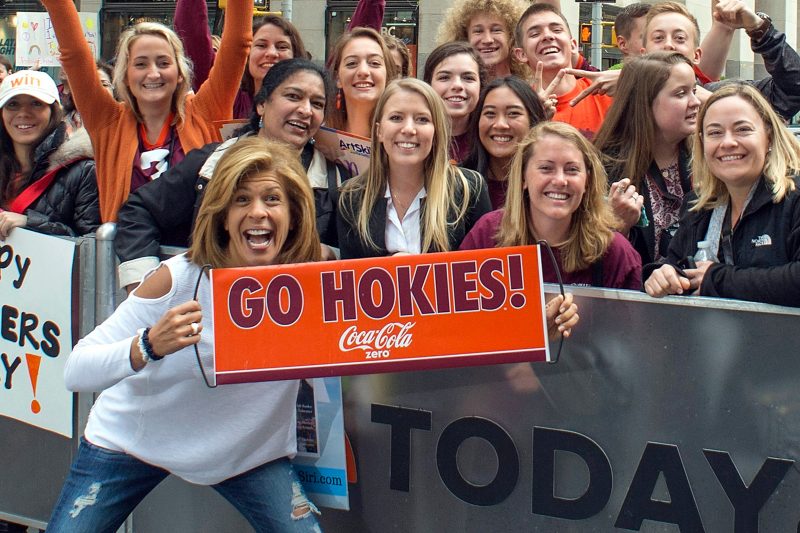 Hoda Kotb stands with Virginia Tech students holding a sign that says, "Go Hokies!"