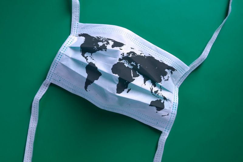 A photo of a mask with a map of the world superimposed over it