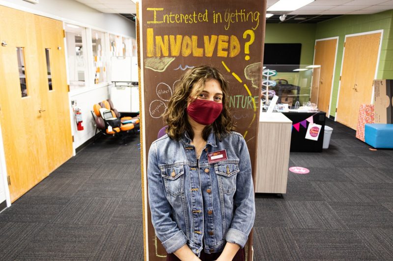 Delaney Tifft stand in front of a sign that reads "Interested in getting involved?"