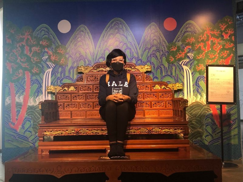 Ursilia Beckles sits on a replica throne in South Korea.