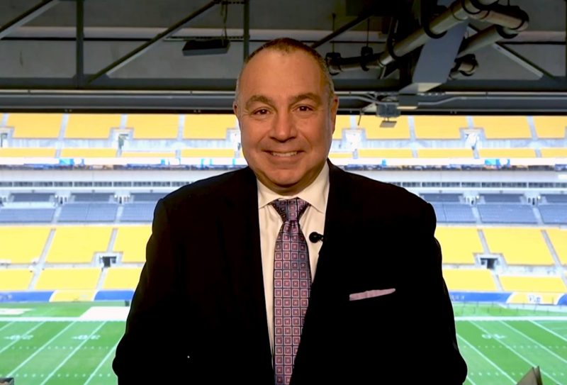Bill Roth stands in front of a sports stadium