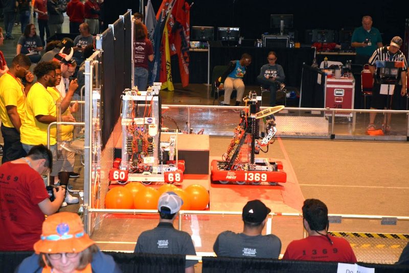 The Delta Overload team (in yellow) with their robot, designated by their team number, 6068.