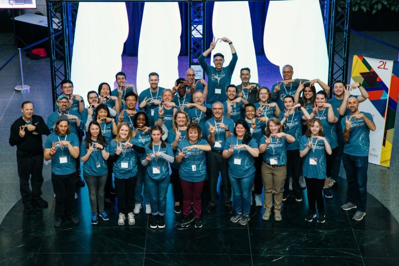 A group photo of faculty, staff, and students who helped put on the ACCelerate Festival, making the VT sign with their hands.
