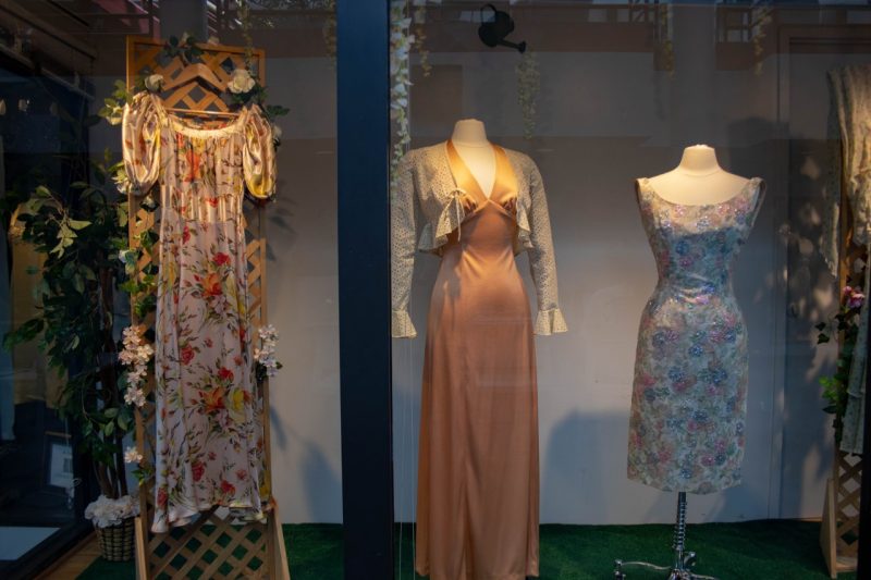 Floral dresses and artificial flowers on display in an exhibition window