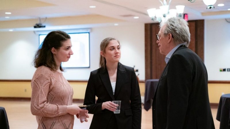 Photo of Dean Paul Knox conversing with honors students 