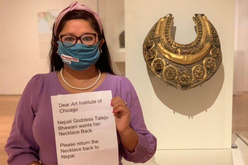 Sweta Baniya takes a photo in front of  a Nepali Goddess' necklace, making a plea for the necklace's return to Nepal.