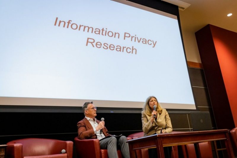 President Tim Sands and France Bélanger, University Distinguished Professor are shown co-hosting a panel discussion on information privacy. 