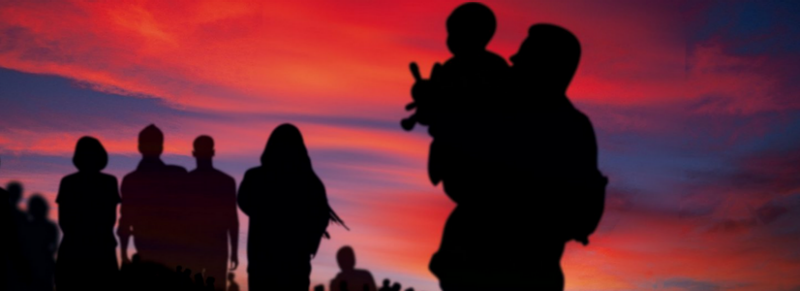 Silhouettes of refugees against a sunset