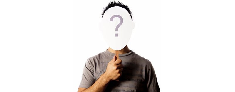 image of individual holding sign that covers their face with question mark